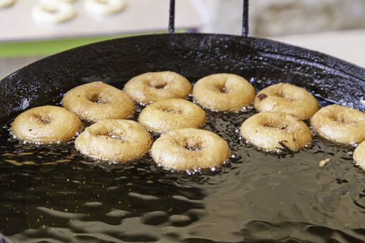 Frying donuts in a market, detail of a kitchen, sweet dessert
