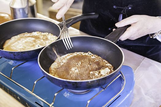 Cooking pancakes on a fair, detail of a position in a market, healthy food, party