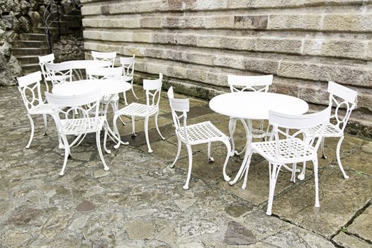 White chairs and tables, detail of a terrace outdoors