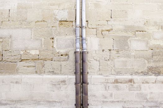 Old pipe in a stone wall, detail of a water pipe