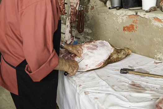 Butcher cutting pork, detail of a person preparing meat