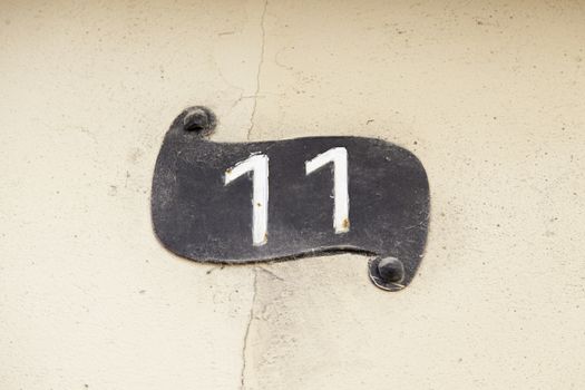 Number eleven on a wall, detail of an odd number of information