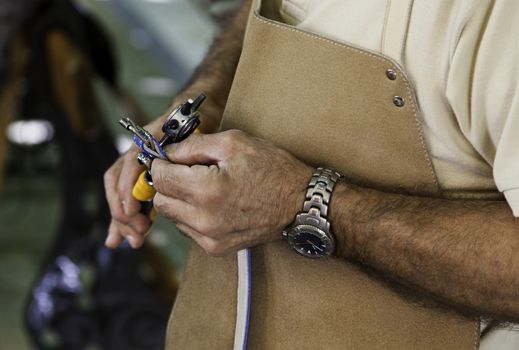 Making holes in a piece of leather, handwork detail, animal skin