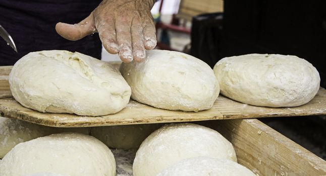 Bakers kneading bread dough in traditional way, artisan work detail, daily meal, healthy living