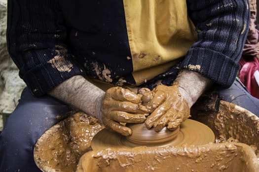 Hands of man working and shaping clay, potter in pottery, craft detail, creation