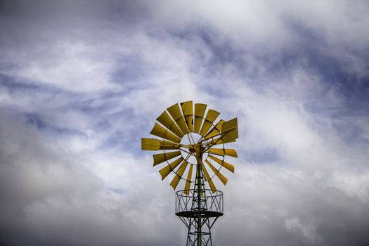 Old metal windmill in a field, detail of heolic energy