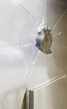 Glass broken and broken by a bullet shot, detail of violence and crime
