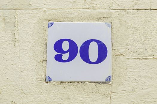 Ninety of information on a wall, detail of even number, address
