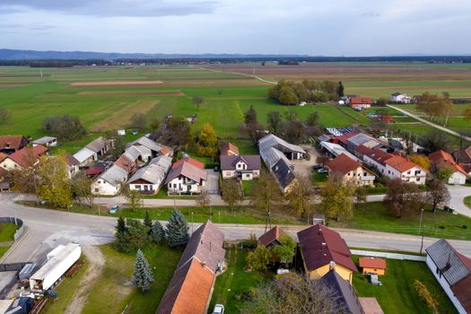 European countryside from the air, village in pannonian plain, Dravsko polje, Slovenia, rural landscape and traditional small villages with houses along the road, village of Podova, Slovenia