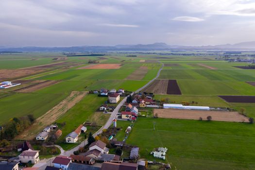 European countryside from the air, village in pannonian plain, Dravsko polje, Slovenia, rural landscape and traditional small villages with houses along the road, village of Podova, Slovenia