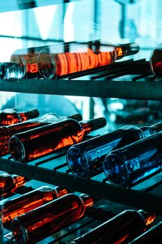 Rows of colourful wine bottles, Detail image of Metal rack with plenty of wine bottles composed in rows for decor.