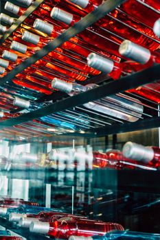 Rows of colourful wine bottles, Detail image of Metal rack with plenty of wine bottles composed in rows for decor.