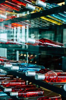 Rows of colourful wine bottles, Detail image of Metal rack with plenty of wine bottles composed in rows for decor.