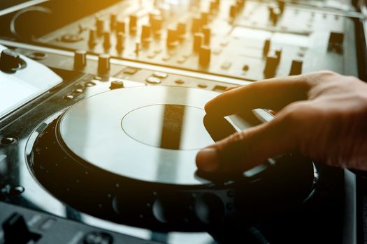 Close up image of DJ turntable console mixer controlling