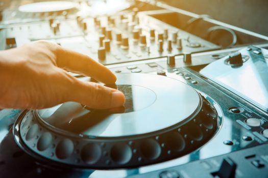 Close up image of DJ turntable console mixer controlling