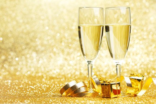Champagne glasses and gifts on glitters background