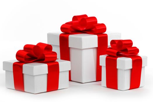 Holiday presents wrapped in white paper with red ribbons, isolated on white