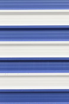 Metal wall painted white and blue, detail of a wall decorated with metallic colors, textured background