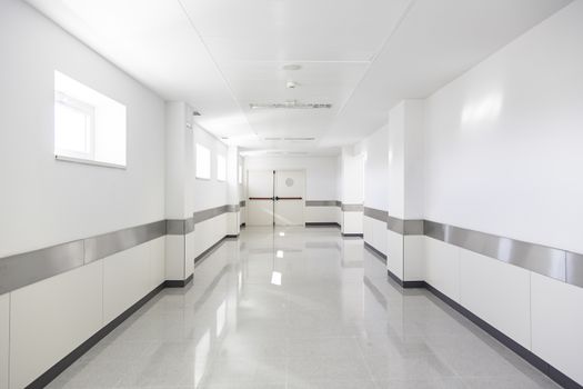 Deep hospital corridor, detail of a white corridor in a hospital, architecture and health