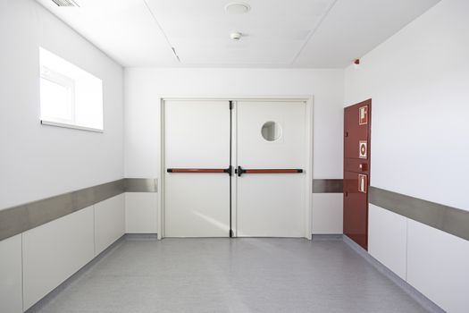 Deep hospital corridor, detail of a white corridor in a hospital, architecture and health