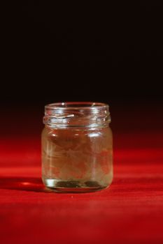 Hand with dipper picking honey from a jar of honey. Jars of honey, bee honeycomb and bee pollen on wooden table