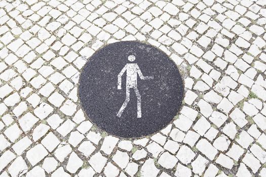Pedestrian sign on the pavement, detail information signal on a street in Lisbon