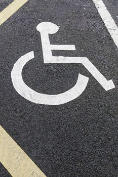 Handicapped sign on asphalt, detail from a diminished signal for people to park, help