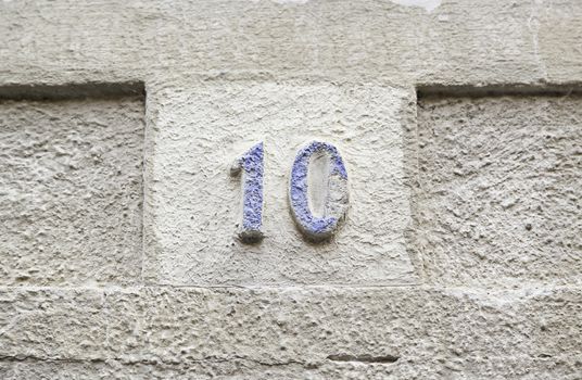 Number ten on a stone wall, detail of a number of information on a wall in the city, ancient and old