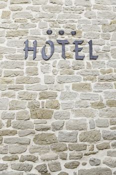 Hotel sign on a wall, detail of an information signal, three star hotel