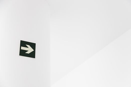 Green Arrow departure, detail of an arrow on a white wall, and safety information