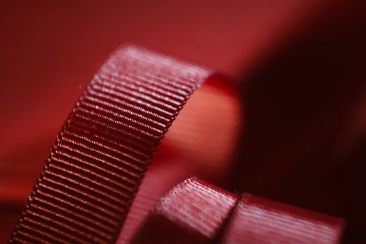 Red ribbon on red wooden table background. Flat lay