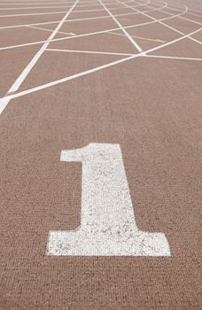 Running track with number one, detail of a running track, with the starting line number one, textured background, sport