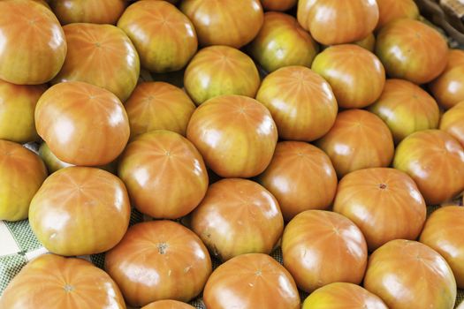 Fresh tomatoes in a market, detail of a red vegetables in a shop in the street, eating healthy lifestyle