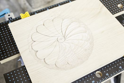 Carved wood with a drawing, detail of a decoration on a wooden board