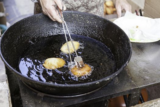 Frying donuts in the street, detail of a market, dessert, food for healthy life