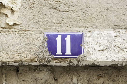 Number eleven on a wall, detail of a number of information in a house