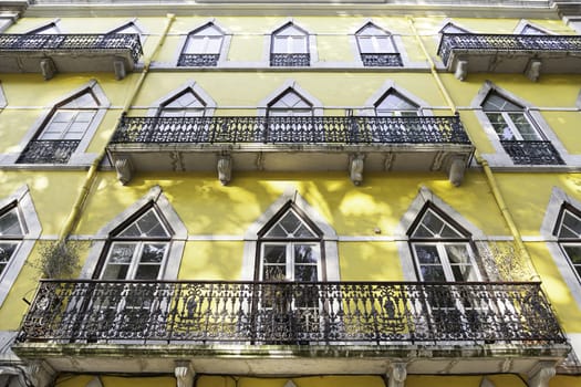 Old yellow facade, detail of an old house painted yellow, Lisbon, Portugal