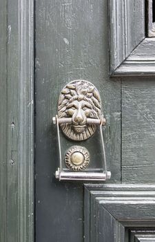 Old caller with a lion head, detail of a decorative bronze door