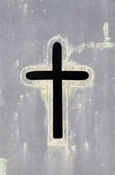 Old rusty metal cross, detail of an old cross on a metal wall, cemetery