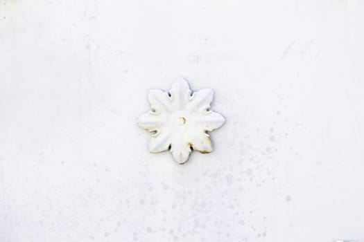 Flower white metal, detail of a wall with a metal flower decoration