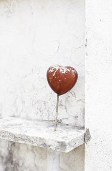 Red heart on marble, detail of a decorative heart on a marble tomb