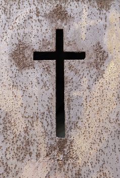 Old rusty metal cross, detail of an old cross on a metal wall, cemetery