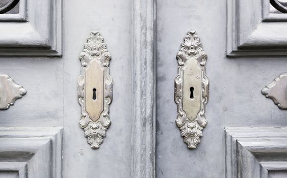 Wooden door with metal knockers, door detail of a decorated, safety and security