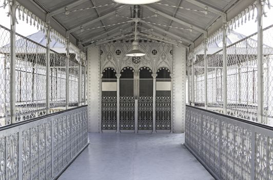 Metallic and deep corridor, detail of a hall with elevator to the background, old