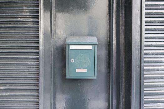Green mailbox on a wall, detail of a mailbox post cartes, correspondence