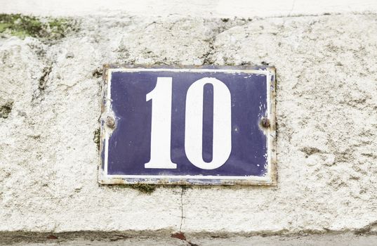 Number ten on a wall, detail of a number of information on the wall of a house