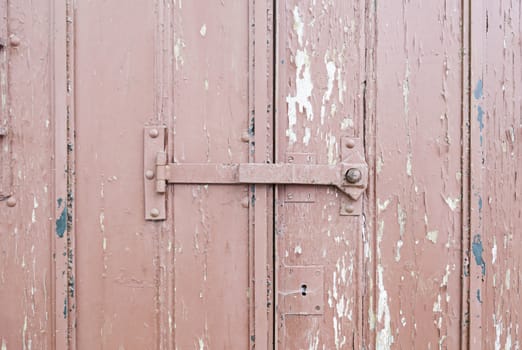 Old door and damaged wood, detail of a closed door, protection and resistance