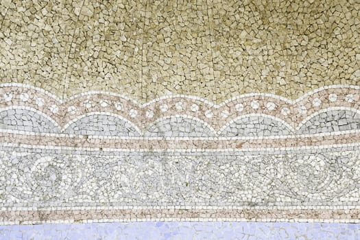 Old stone mosaic, detail of a wall decorated with colored stones, textured background