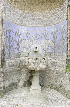 Old fountain with stone mosaics, detail of a water fountain, ancient art