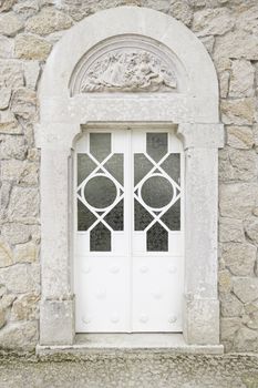 Old closed white door, detail of a wall with a door protection and decoration